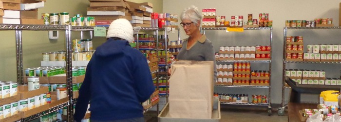 Person in food pantry with volunteer