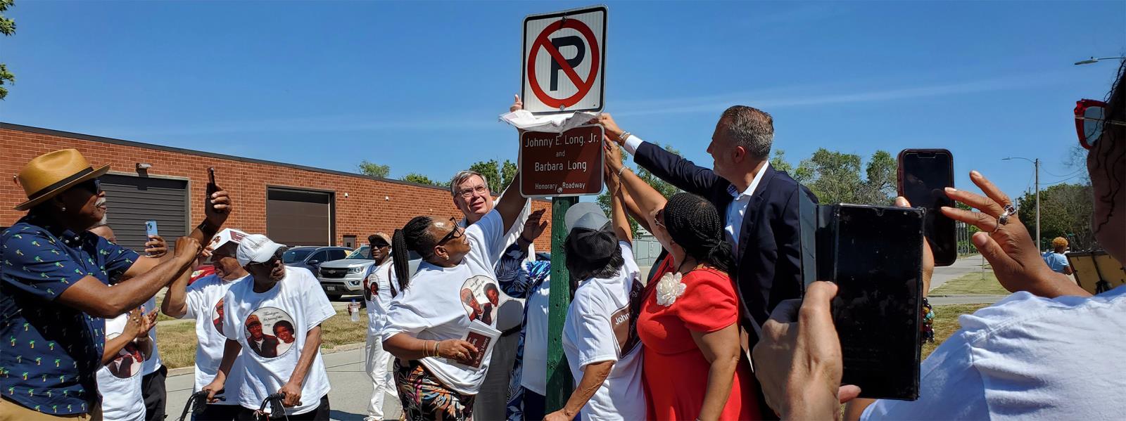 The Long Family and city official unveil the Long Family street sign